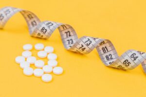 weight loss pills and tape measure