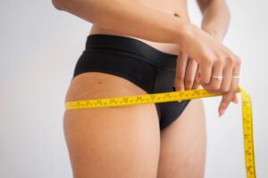 woman measuring weight loss on body while on semaglutide